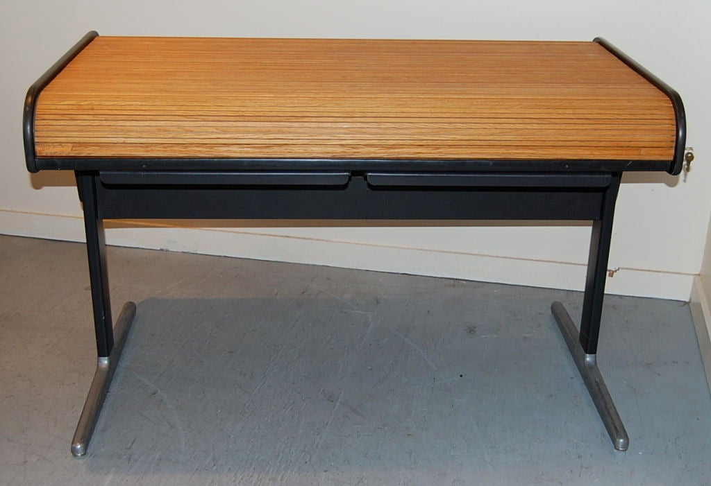 George Nelson designed roll top desk for Herman Miller from his Action Office Series. The  roll top and slightly angled work surface are oak,  with laminate sides and a metal base with aluminum feet. An auxiliary storage/file compartment is located 