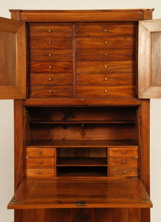 An 18th century French secretaire abattant with an upper cabinet with 2 doors concealing 12 small drawers, a middle drop front desk, and a lower two-door cabinet concealing shelves, in walnut, circa 1780.