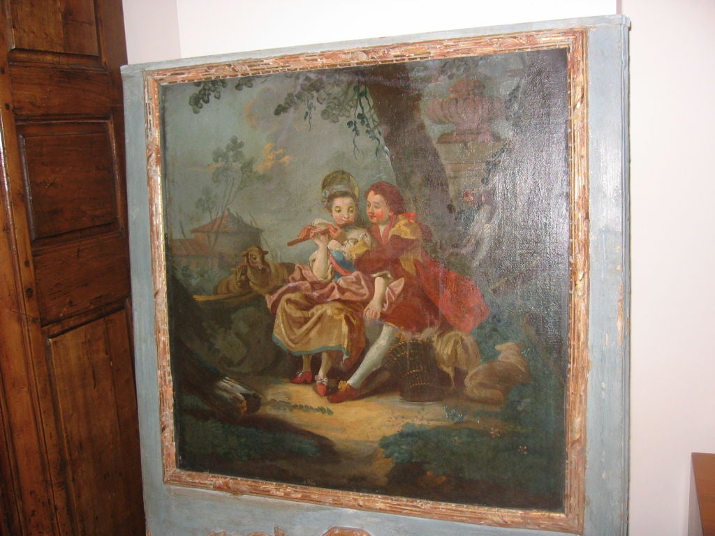 A period Louis XV trumeau with a nicely painted canvas panel depicting lovers in a garden, over an original mercury plate mirror, in a blue painted and parcel-gilt frame.