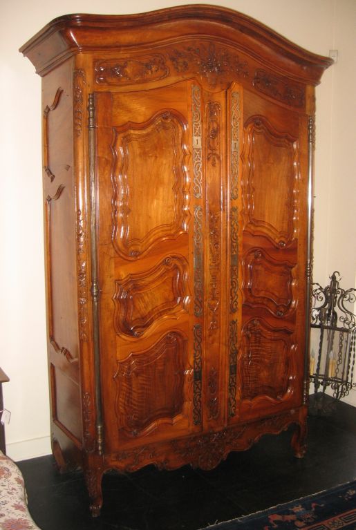 A museum quality Louis XV armoire in walnut with beautifully carved and panelled doors, a chapeau gendarme cornice, great iron hardware, and carved cabriole legs.  The armoire was part of a private collection assembled by the two gentlemen who