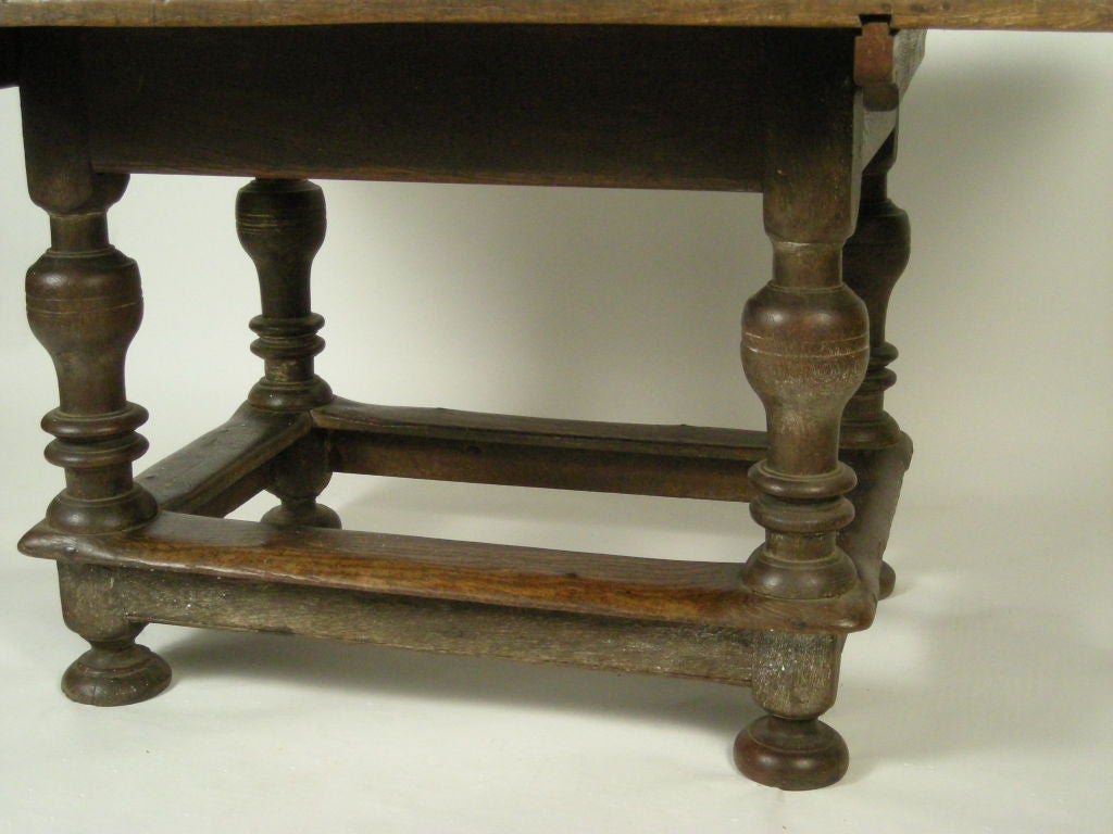 New England Pilgrim Century oak and pine tavern table, the boldly turned legs joined by stretchers, surmounted by an old, but later associated top in patinated pine. Strong, graphic form. Provenance: The Richmond Collection, Connecticut.