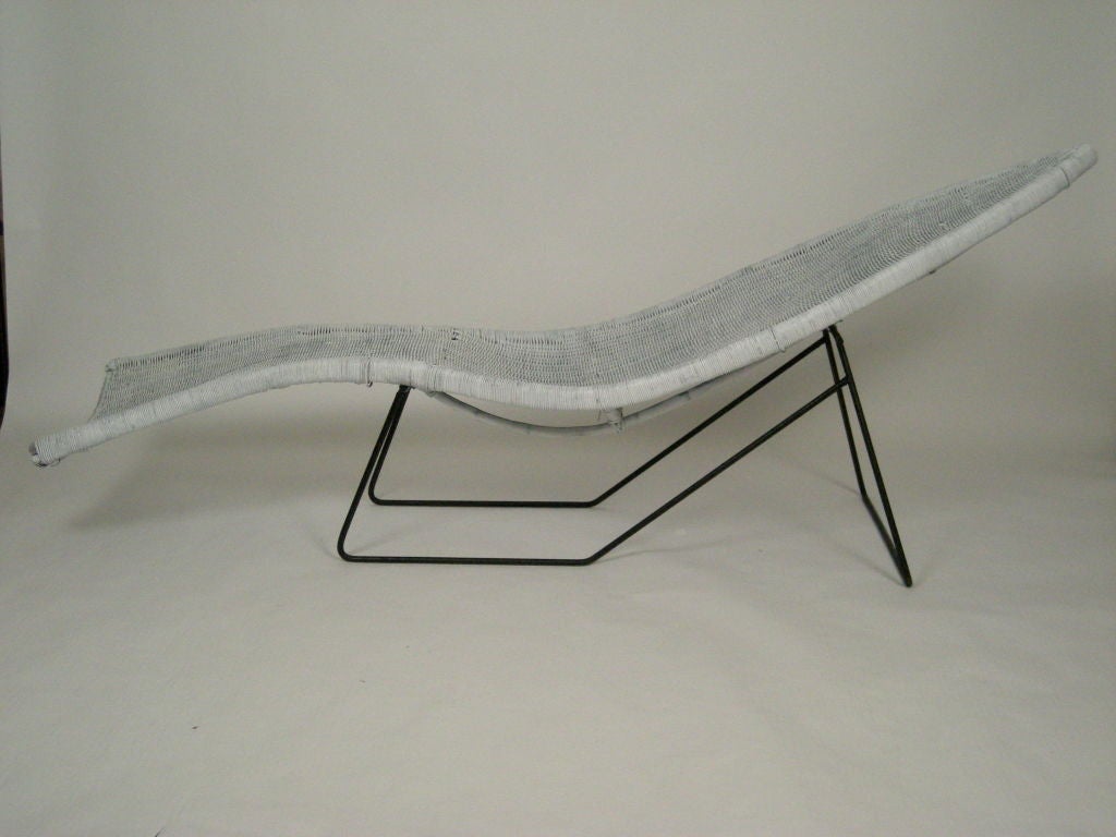 Sculptural white painted fish-form wicker chaise longue with tubular metal base. Solid and comfortable.