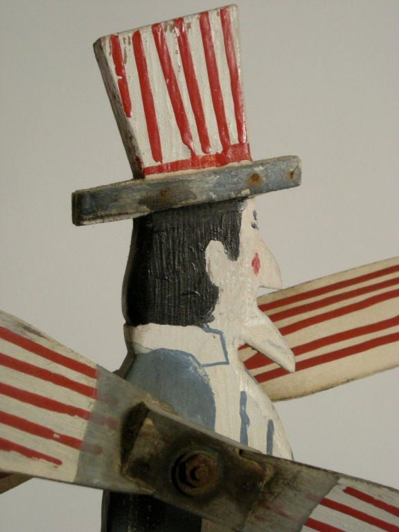 Whimsical Uncle Sam whirligig, hand carved and painted by 'Barber', a folk artist from Narragansett, Rhode Island. Mounted on a black painted rectangular base.