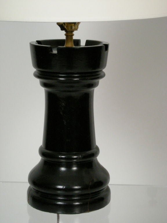 Pair of ebonized wood giant chess piece (rook) lamps, from an out door chess set. Drilled for lamps; newly rewired, with cream colored paper shades and brass finials.