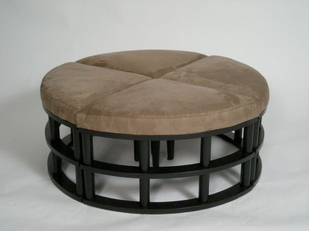 Round ottoman in 4 quarter sections, upholstered  in ultra-suede,  with black painted  base. Ideal as coffee table and for additional occasional seating.