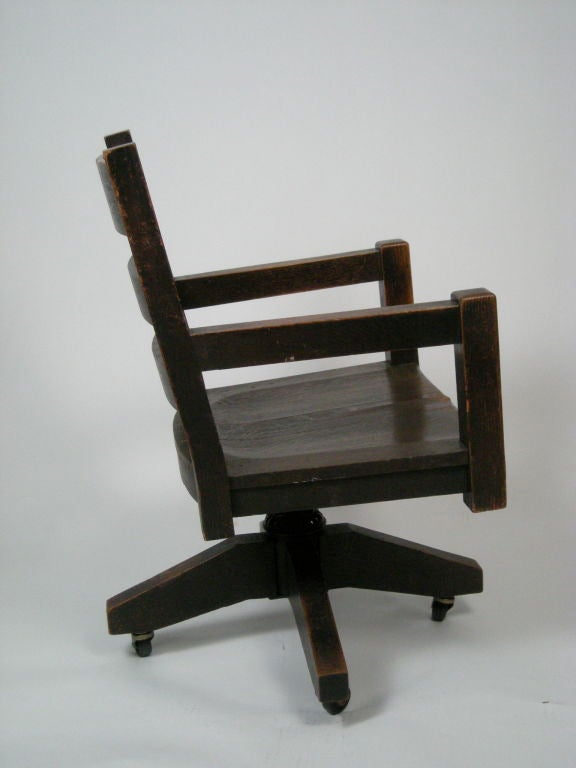 Arts and Crafts period dark stained,  quarter-sawn, solid mission oak swivel desk/office chair. Rotates 360 degrees and tilts comfortably back. Original surface.