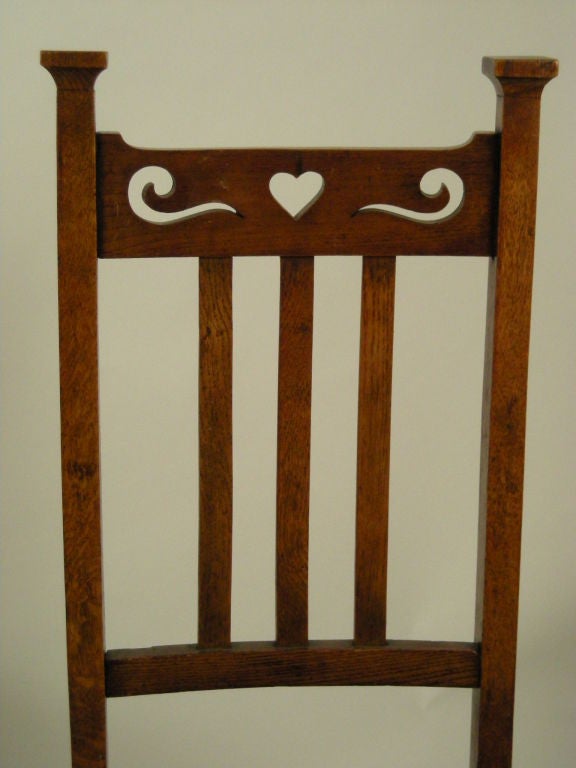 Set of 6 Scottish Arts & Crafts dining chairs, comprising 4 side chairs and 2 arm chairs, the backs with cut out heart and scroll decoration, the seats newly re-covered with fine quality green leather and antiqued brass tacks.