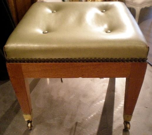 A small fruitwood stool on castors with nice tapered legs and a upholstered seat.