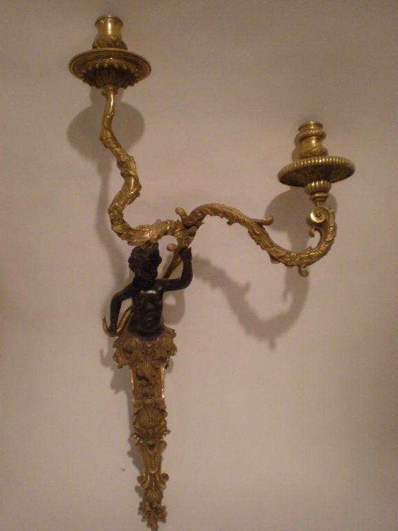 Pair of exceptional gilt bronze two armed sconces with putti, they are hand forged and chased.