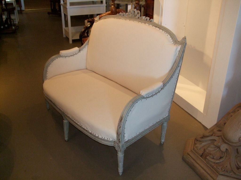 Small scale gray painted settee with carved ribbon crest.