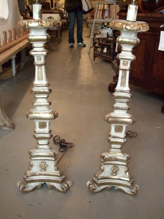 Pair of tall paint and gilt candlesticks with original paint wired as lamps.