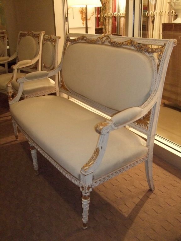 Newly upholstered paint and gilt Louis XVI style suite of furniture in a grey ultra-suede. 

Willing to split the set, two armchairs, four side chairs or the settee!

Settee 28 D X 56.5 W X 40.5 H X 18 SH X 26.5 AH $2,400

Two armchairs 25 W X
