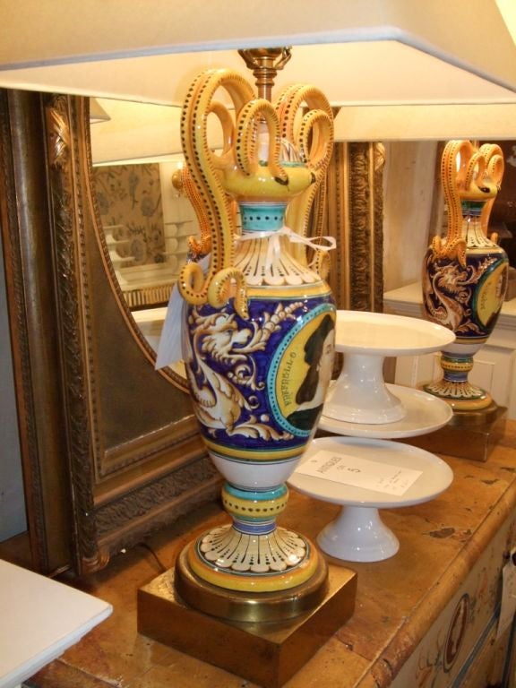 Pair of 2-arm hand painted pottery lamps with square brass bases. Portraits of Beatrice D'Este and Raffaelo Sanzio. Price is for the pair.