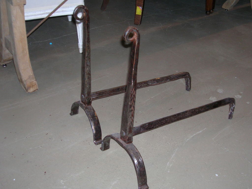 18th century scrolled top andirons with arched feet and incised decoration.