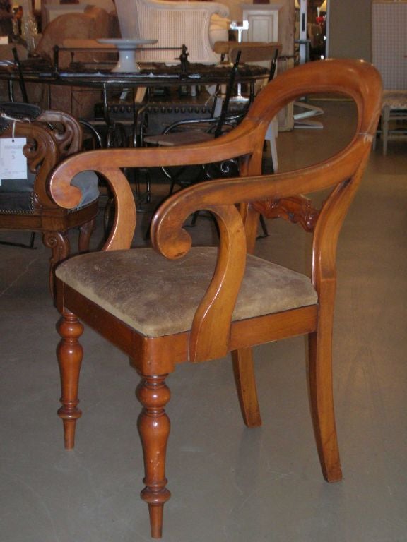 Carved walnut armchair with original leather seat, turned legs and decorative carved back splat.