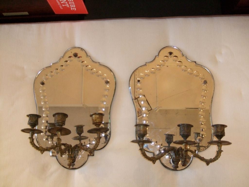 Pair of three arm bronze and Venetian mirrored sconces with decorative border.