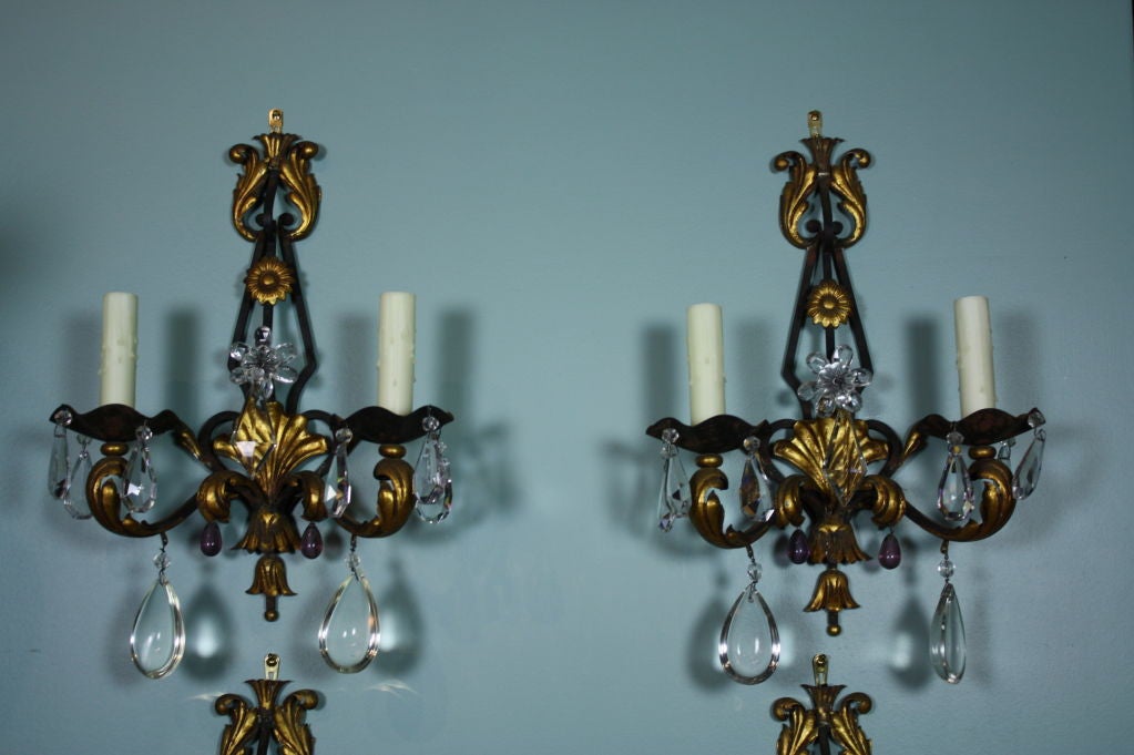 Pair French iron sconces with gilt-tole detailing, and clear and colored crystals in the style of Maison Bagues. To be re-electrified, each with two lights.