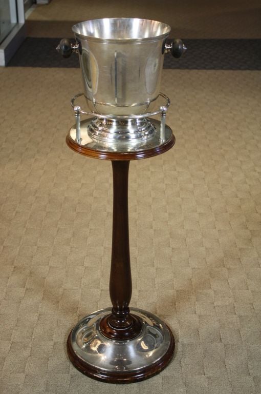 Beautiful, sleek, silver-plated champagne bucket on mahogany stand by Christofle of France, with turned wood handles, art deco style.
