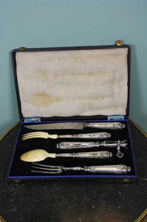 A finely-chased French .950 fine silver five-piece carving service comprising a caving knife, a carving fork (with adjustable resting stand for raising it off of the table), a serving fork with bone tines, a serving spoon with bone bowl, and a