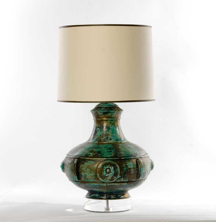 + An overscale lamp with a great three-dimensional quality<br />
+ Glaze mimics that of aged copper...shades of turquoise green,brown, gold<br />
+ Layered effect of glaze is mottled throughout. Raised areas on the surface create the apperance of