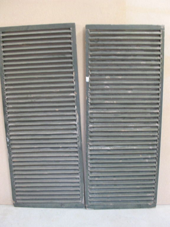 Two sets of wood shutters and one set of iron window grates.  All have great character and peeling paint.<br />
Large Shutters: 67.5