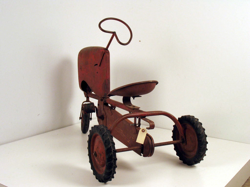 Child's pedal-powered steel tractor with hard rubber wheels.<br />
(probably 1950 BMC Heavy Duty Senior: model #918-06772)