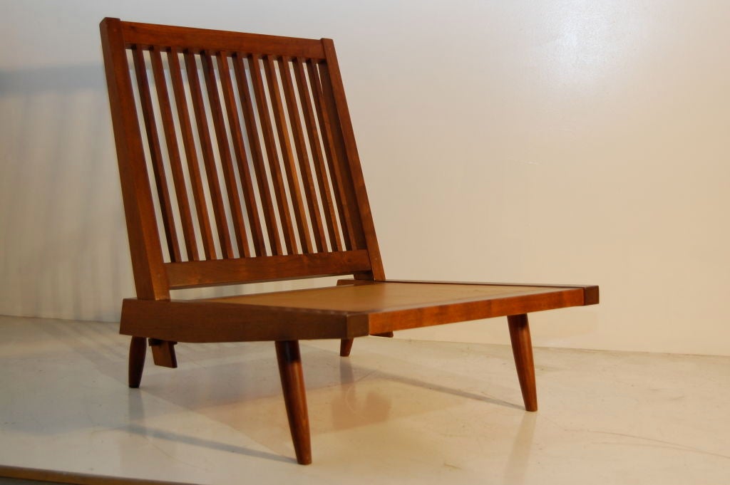 George Nakashima Walnut cushion chair with the original green yellow with red fleck fabric cushions still in place .