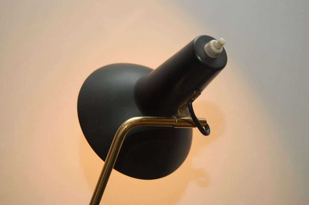 Vittoriano Vigano for Arteluce , 1950 , desk lamp in black enamelled metal over hollow brass stem , full label to inside rim of shade , head is multi-positional , rotating on the stem , an ingenious solution which does away with the need for a ball