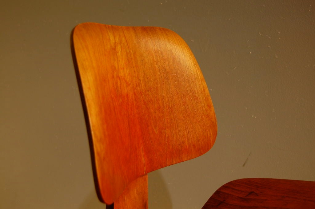 Charles and Ray Eames for Evans Products ; a red analine dye Dining Chair Wood ( DCW ) , original shockmounts and hardware , label dating the chair to 1948 . Fine original example
