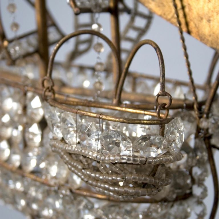 Gilt metal chandelier in the shape of a galleon with numerous faceted glass beads. The gilding is in excellent original condition.