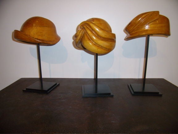 Beautifully carved wooden hat molds. On stands. Hats are 5 to 7 inches high and approximately 17 inches tall on the stands