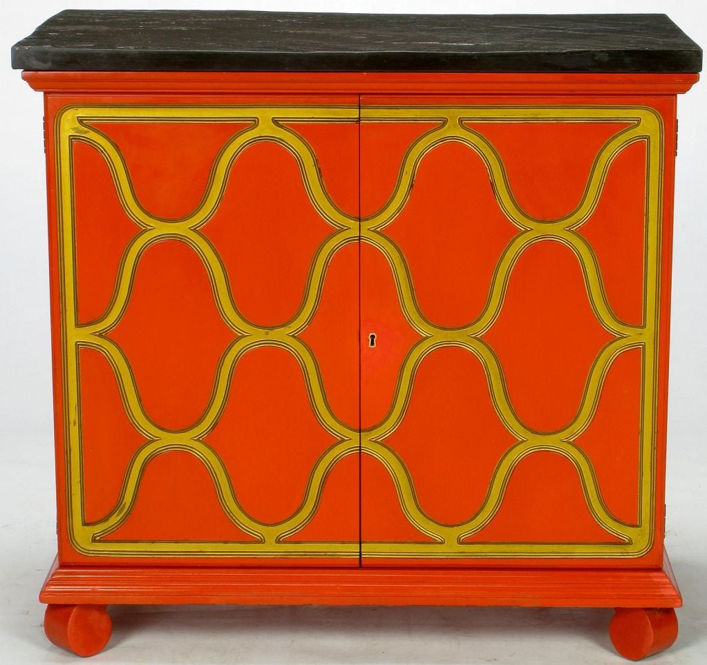 Dorothy Draper Espana Collection for Heritage two door cabinet in stunning Castilian Red (red-orange) matte lacquer with carved and gilded doors. The natural flagstone slate top is original, and the drop ring side handles are of solid brass.