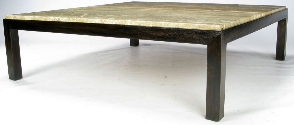 Large, low and elegantly simple, this parsons style coffee table by Edward Wormley for Dunbar has a one inch thick, beautifully cut, travertine top. The base is dark solid walnut.
