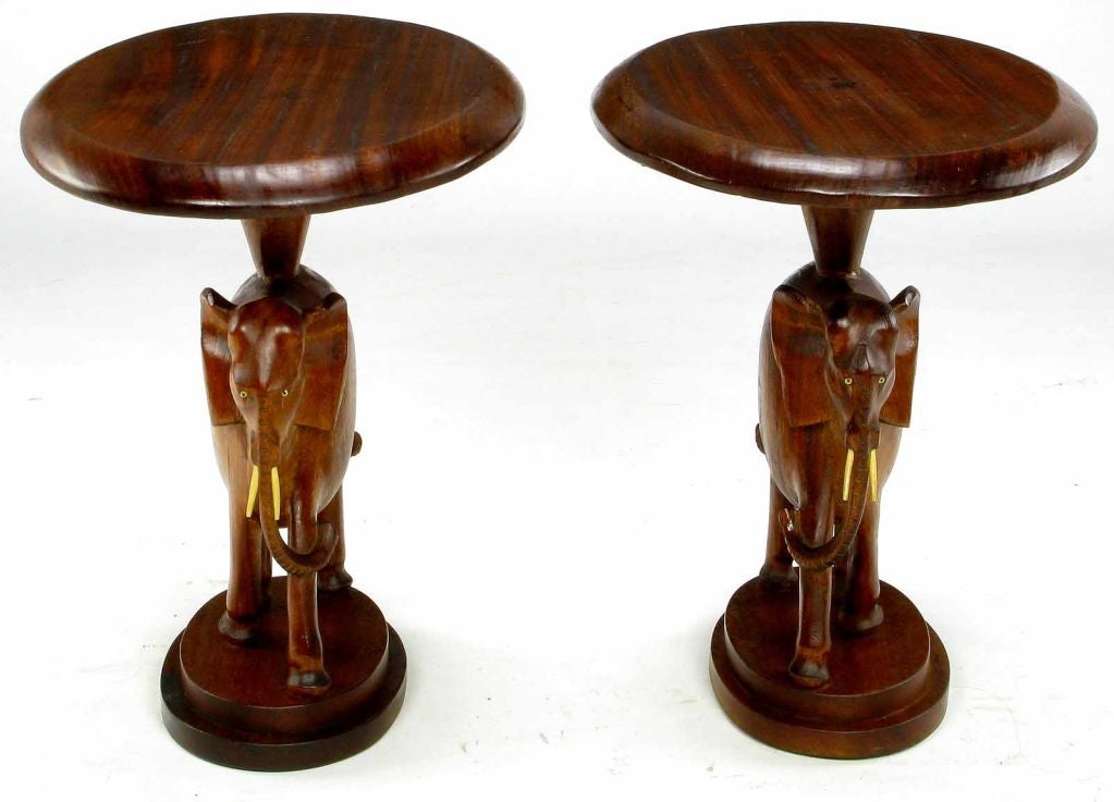 Expertly hand carved artisan end tables in the form of elephants marching. Solid wood with ivory tusks and eyes, these are truly one of a kind pieces.