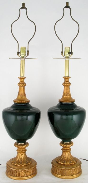 Élégantes et inhabituelles, ces lampes de table en verre coffré vert et gesso doré sont assez grandes et exceptionnelles. Sous la harpe se trouve une barre percée qui permet d'accrocher des glands décoratifs, à la manière de l'époque. Vendu sans