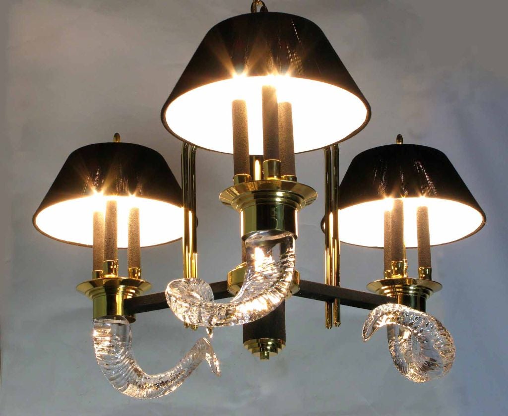 Unique and elegant, this three arm, 9 light chandelier is a 1980s deco revival piece. Crystal rams' horns, solid brass, black textured metal with three hand wrapped black wool shades, and enough brass chain to hang from a high ceiling.