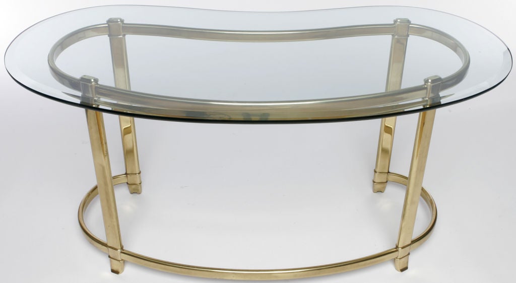 Stunning kidney shaped writing table, or desk, with beveled glass top and brass base.