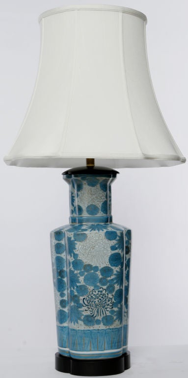 Colorful pair of Asian porcelain lamps.  Urn form bodies of turquoise and white floral decoration, mounted on four-lobe ebonized bases.  New shangtung silk shades echo the shape of the bodies and bases.