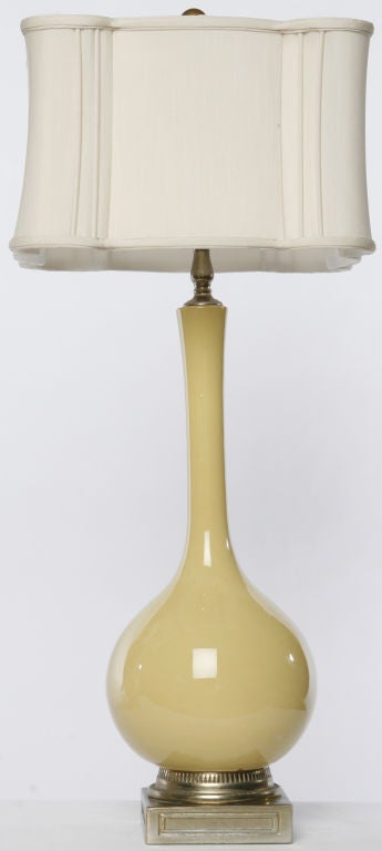Unusual pair of ceramic lamps with Dijon yellow glaze.  Bases are brass with foliate details.  New square shades in an uncommon style.