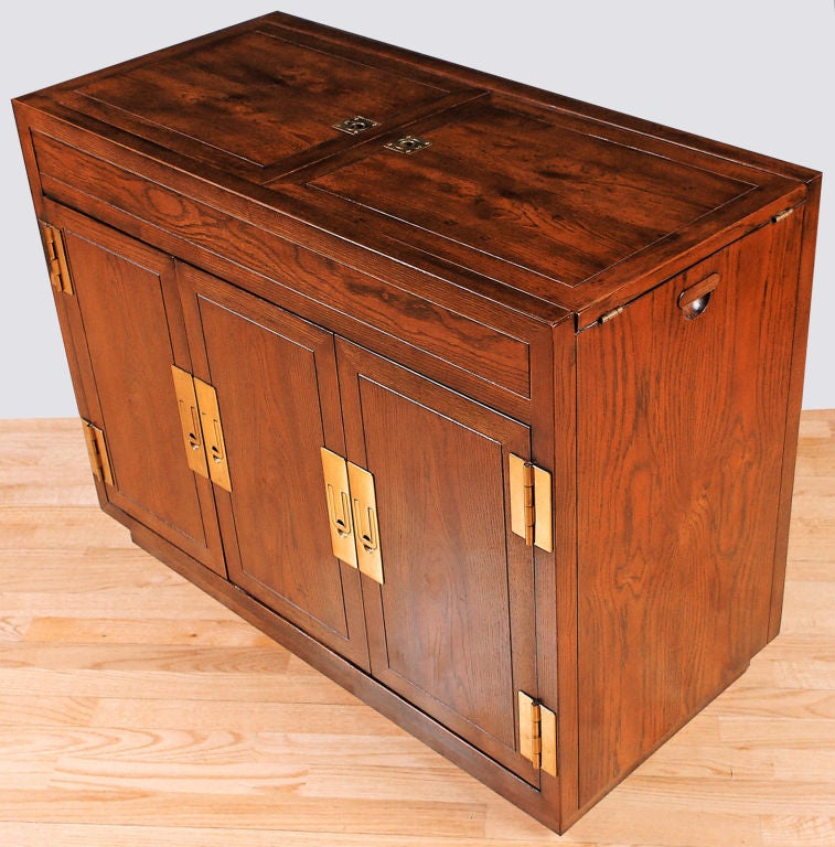 Elegant bar or server cabinet with bookmatched elm veneer doors and case.  Door pulls and hinges are a modern interpretation of the traditional brass campaign hardware.  <br />
<br />
The top is divided into two halves that flip to double the