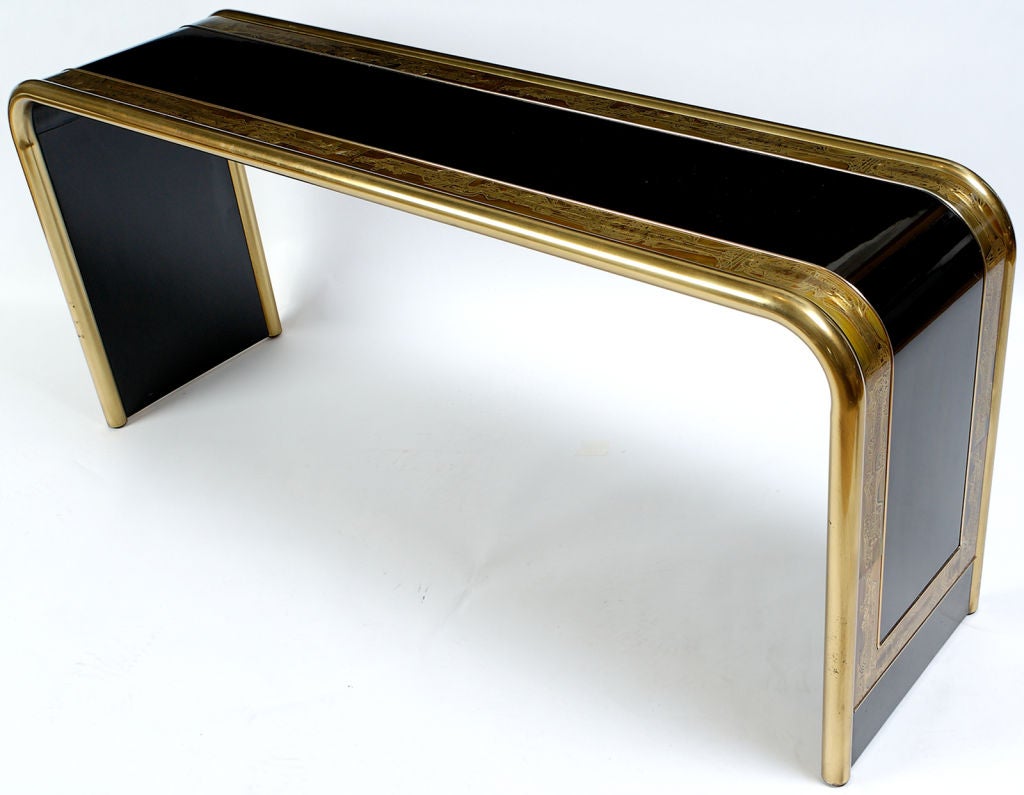 Elegant console or sofa table executed impeccably in black lacquer with rounded bronze trim.  Decorated with etched brass overlay panels by artist Bernhard Rohne.
