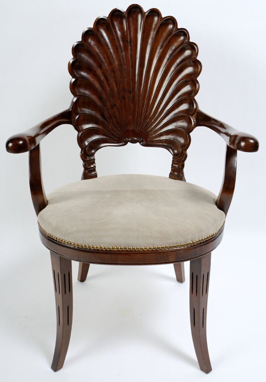 Beautifully carved with a shell form back, and a seat upholstered in a taupe suede trimmed with brass nailheads, these chairs were made in Italy for Bamberger's department store.