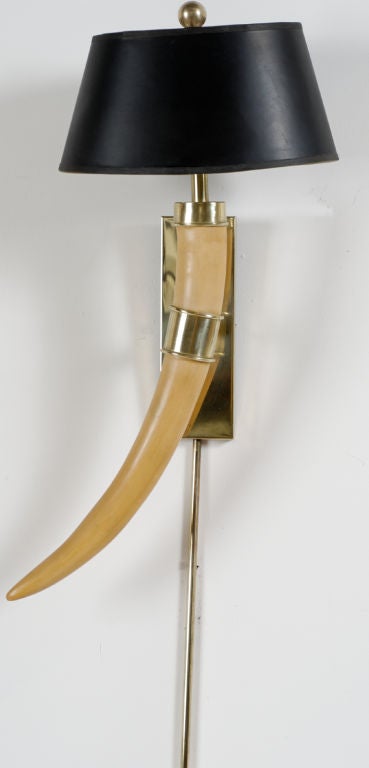 Elegant pair of sconces by Chapman. Faux tusks with brass mounts are fastened to brass backing plates.  Original black shades with faux tortoiseshell gold linings.