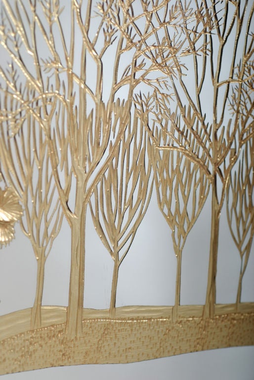 Wall mirror with gold metal frame and gold forest scene in reverse applied metal leaf.