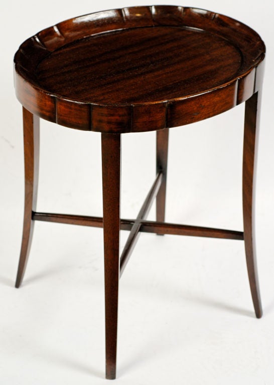 This well-proportioned side table, or gueridon, has a scalloped tray top.  Four splayed legs are joined by X-form stretchers.