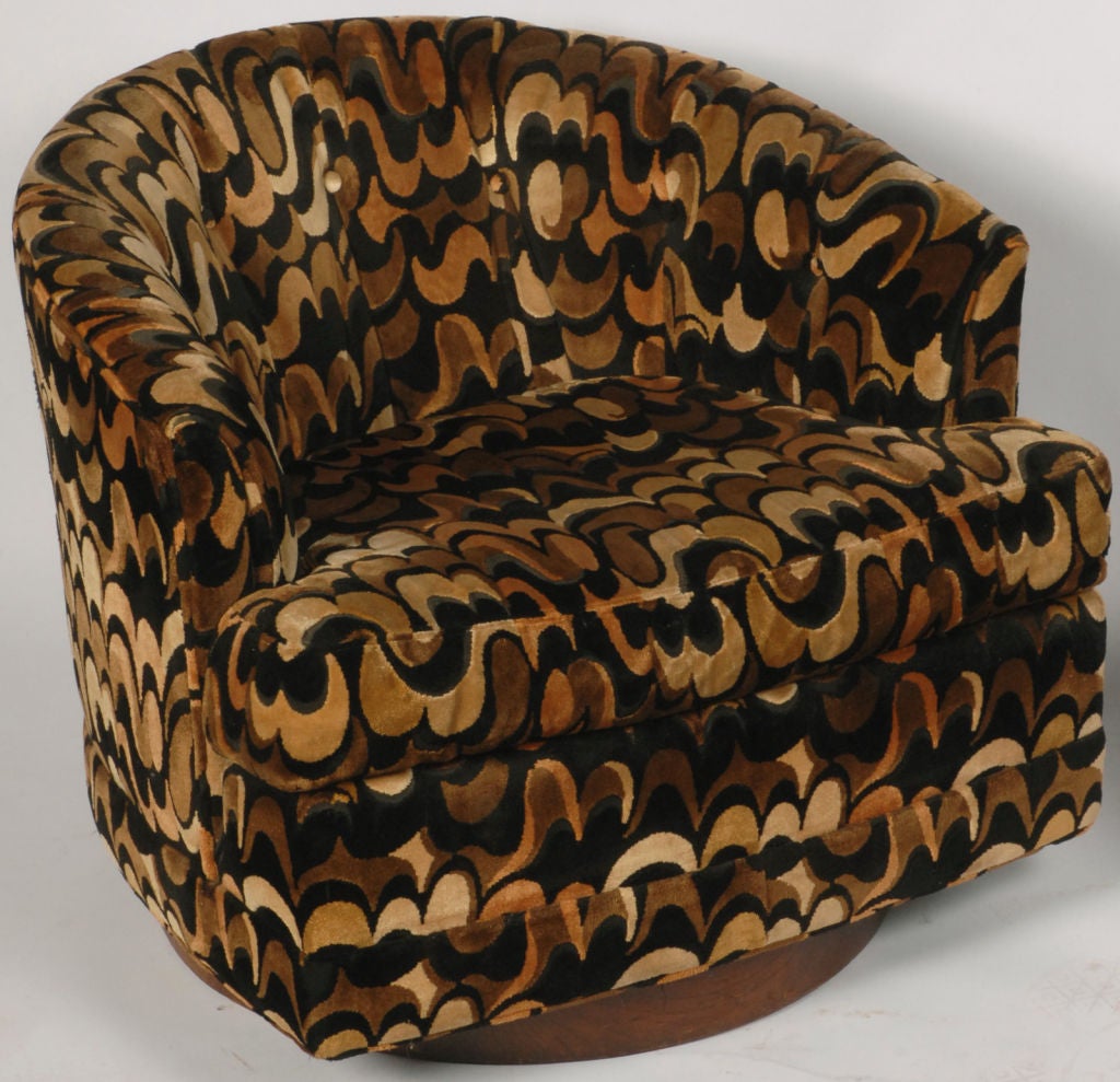 Most likely from the late 1960s, these extremely comfortable chairs swivel on walnut wood bases.  Covered in a Jack Lenor Larsen style velvet that appears to have faded spots, although that is the original pattern of the fabric.