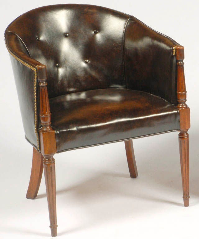 Mahogany Regency-style chairs upholstered in a very dark brown leather with brass nailhead trim.