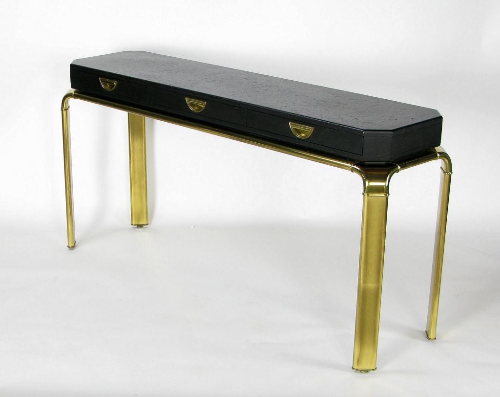 Three drawer console table with black texture over wood case, resembling ostrich skin, mounted to brass base. Finished on all four sides.