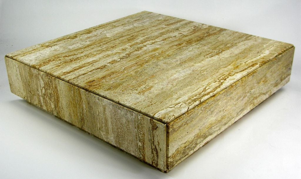 Appearing to be a solid square of stone, this incredible table is made highly figured and colored travertine.  Set upon a recessed plinth base, reveals at every joint add additional interest.