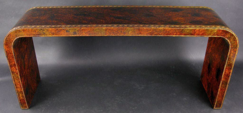 In a classic waterfall form, used often by Karl Springer, this custom console table is stunningly finished in a hand-stippled glazing over a Chinese red lacquer base to simulate tortoise shell.  <br />
<br />
The top and sides are decorated with